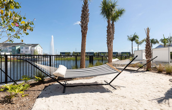 hammocks over sandy area beside Lake Nona Concorde's fenced pond