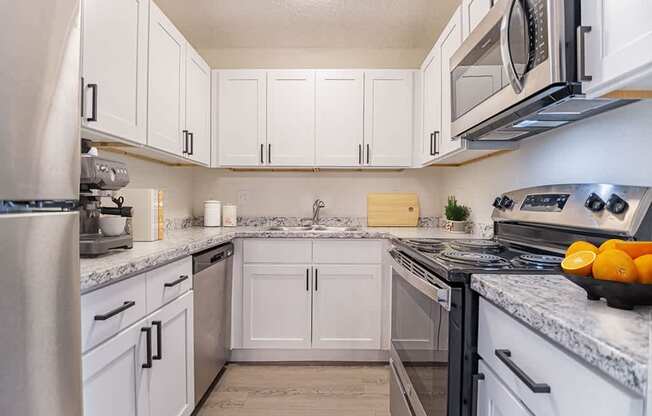 a kitchen with white cabinets and stainless steel appliances