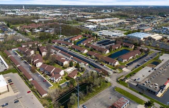 an aerial view of a neighborhood of houses and cars in a parking lot