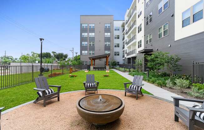 A courtyard with a fountain and chairs.