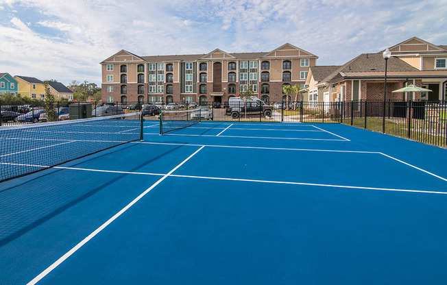 two tennis courts with apartments in the background