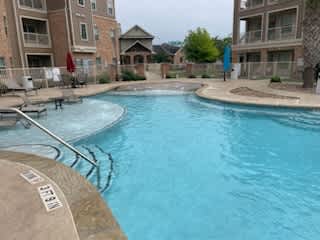 A swimming pool in a residential area with a building in the background.