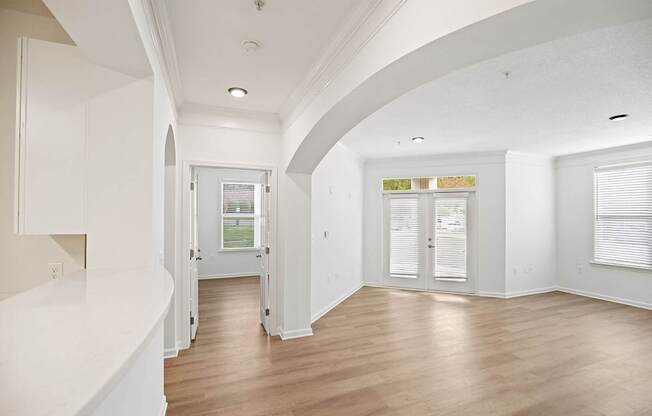 A white interior with wood floors and a window.
