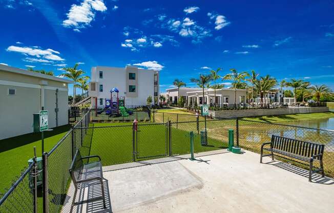 a fenced in area with a tennis court and benches at Altis Santa Barbara, Naples, Florida