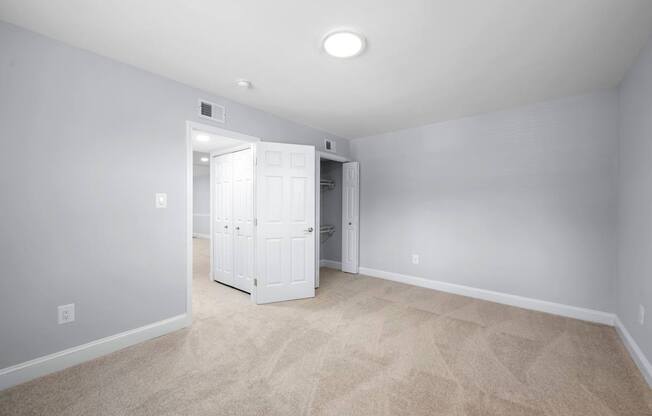 A room with a white door and carpeted floor.