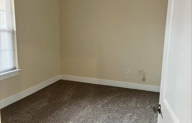 a room with a carpeted floor and a ceiling fan