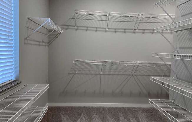 the walk in closet of a home with empty shelves