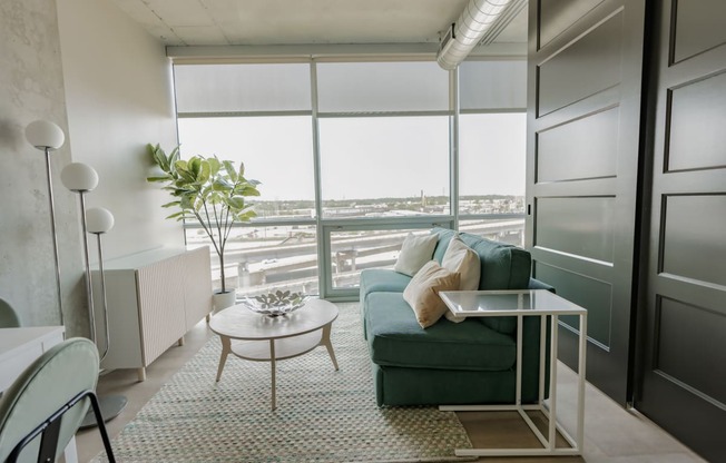 a living room with a green couch and a table and a windowat One Foundry Way, St. Louis, Missouri