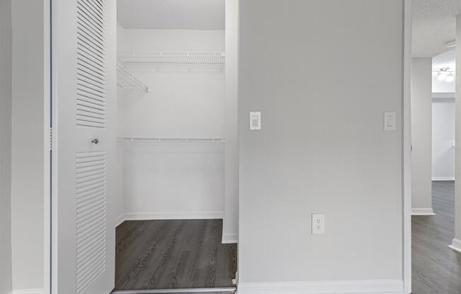 an empty closet in a room with white walls and wood floors