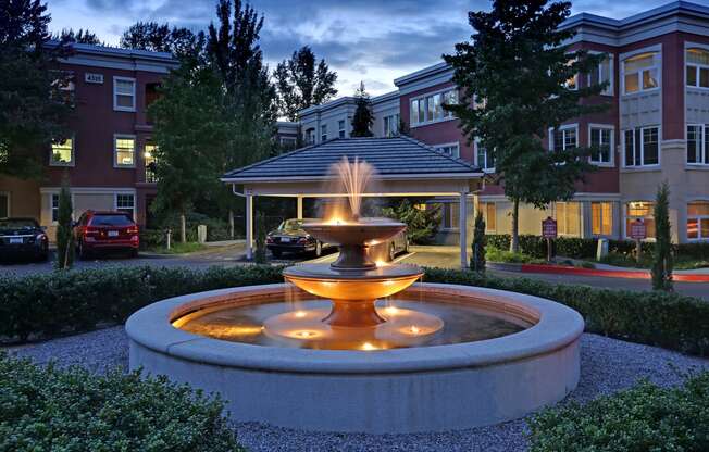 a fountain in front of a building at dusk