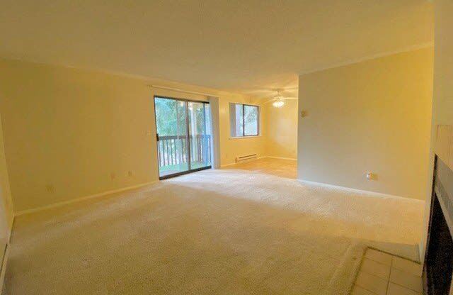 an empty living room with a door to a balcony