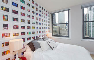 a bedroom with a bed and a wall covered in photos