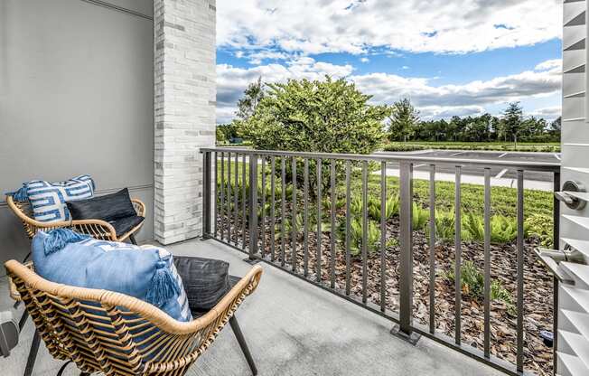 a balcony with two chairs and a view of a garden at The Overlook, Winter Garden, 34787