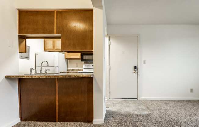 an empty kitchen with a counter and a door to a room at Pheasant Run in Lafayette, IN 47909