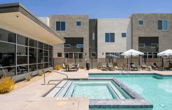 a swimming pool with chairs and a building in the background at Novella Biltmore, Phoenix, 85016