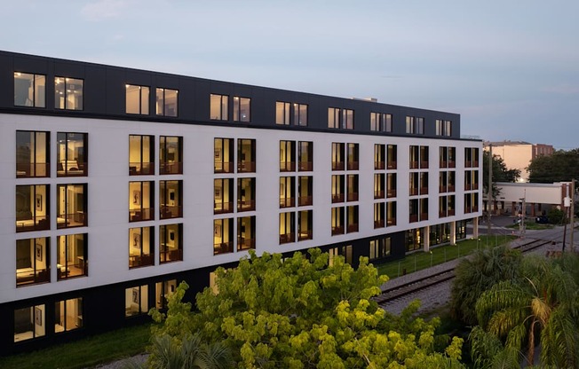 the facade of a large office building with windows lit up at night