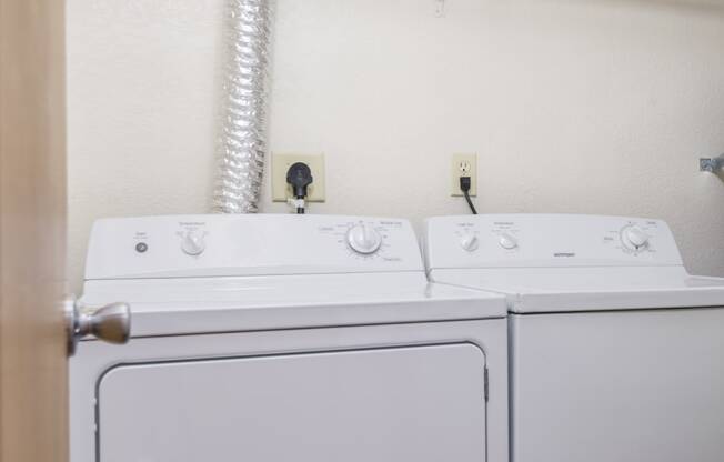 a white washer and dryer in a room with a door