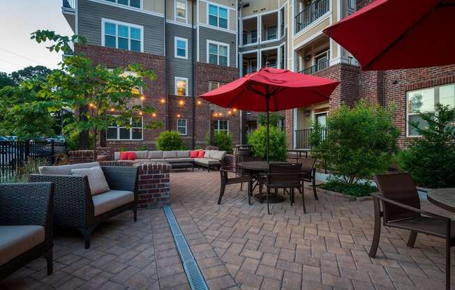 A patio with a table and chairs and umbrellas.