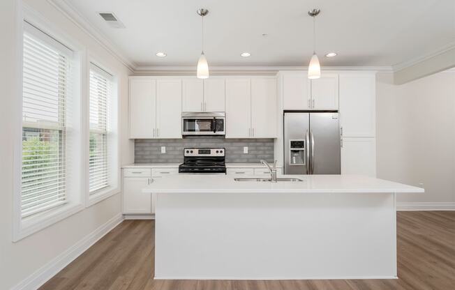 a kitchen with white cabinets and a large island