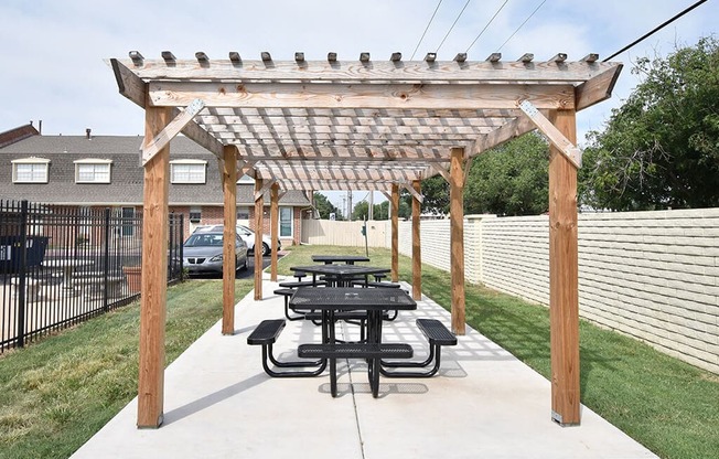 A wooden pergola with a picnic table underneath it.