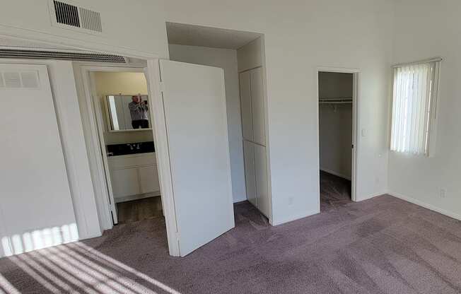Large bedroom with walk-in closet, storage cabinets and bathroom at Northwood Apartments in Upland, California.