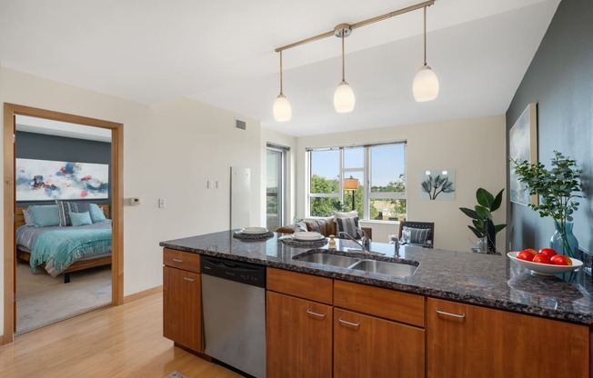 an open kitchen and living room with a bedroom in the background