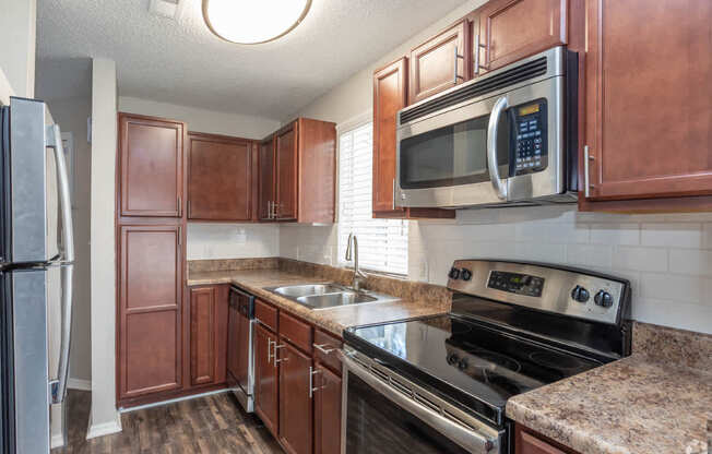 A kitchen with brown cabinets and a black stove top oven.