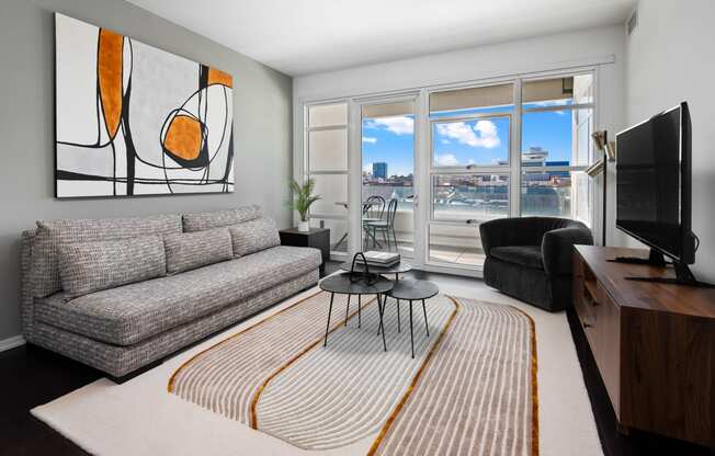 a living room with a couch and a tv and a balcony