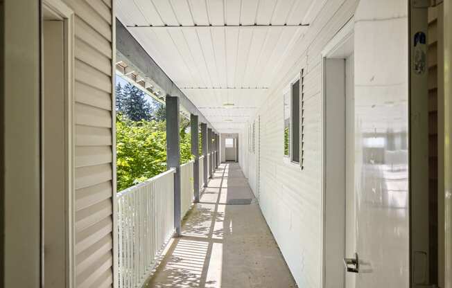 a long porch with white siding and a white railing at Mill Pond Apartments, Auburn Washington