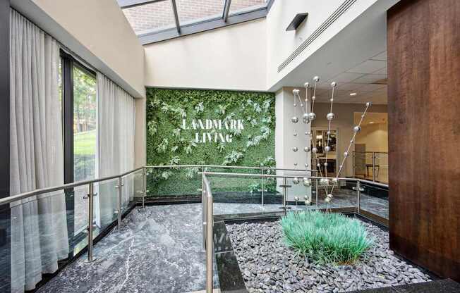 A hallway with a glass wall and a green plant in the middle.