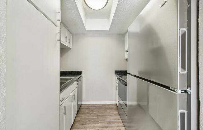 a kitchen with white cabinets and stainless steel appliances