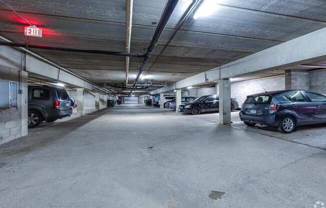A parking garage with a red exit sign.