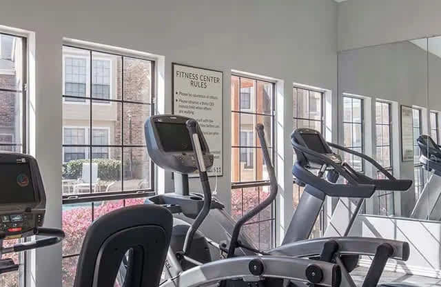 A fitness center with treadmills and a sign that states the rules.