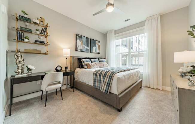 A bedroom with a bed, desk, and chair.