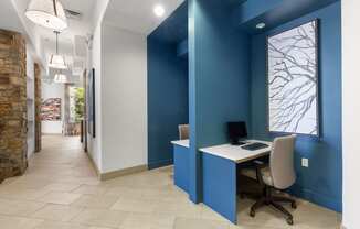 a home office with a desk and a computer in a hallway