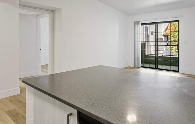 A large, empty room with a black countertop and white walls.