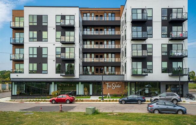 a large apartment building with cars parked in front of it