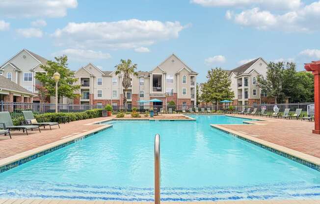 A swimming pool in front of a row of houses.