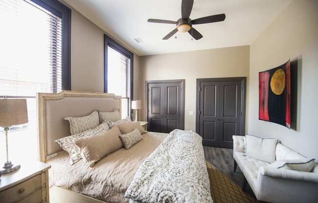 a bedroom with a large bed and a ceiling fan at The Knights @ 506 Delaware Apartments, Buffalo, 14202