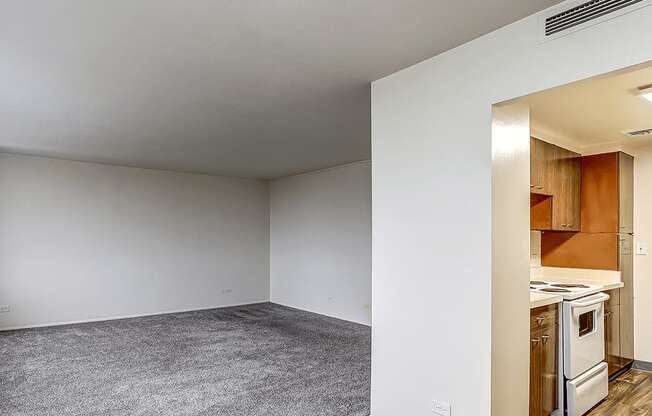 A kitchen area is visible through an open door in a white room.