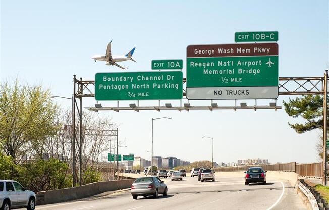 a plane flying over a highway with cars on it