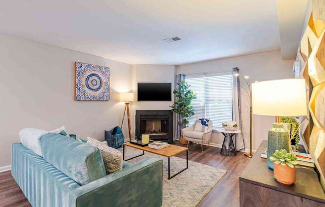 A living room with a blue couch and a fireplace.