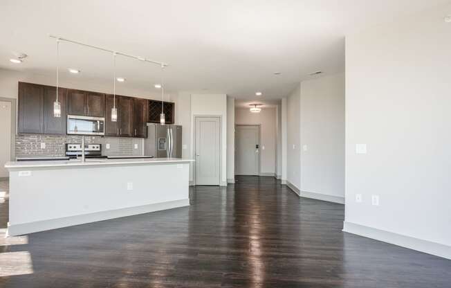 an empty kitchen and living room with white walls and wood floors