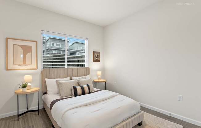 A bedroom with a large bed and a window with blinds.