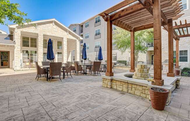 a patio with tables and chairs and a pergola