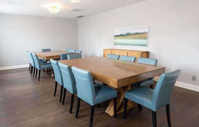 a dining room with a long wooden table and blue chairs
