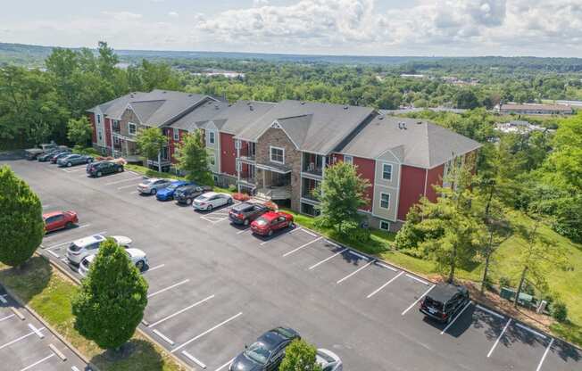 an aerial view of a parking lot and apartment buildings with cars parked