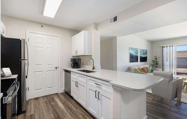 A kitchen with white cabinets and a black refrigerator.