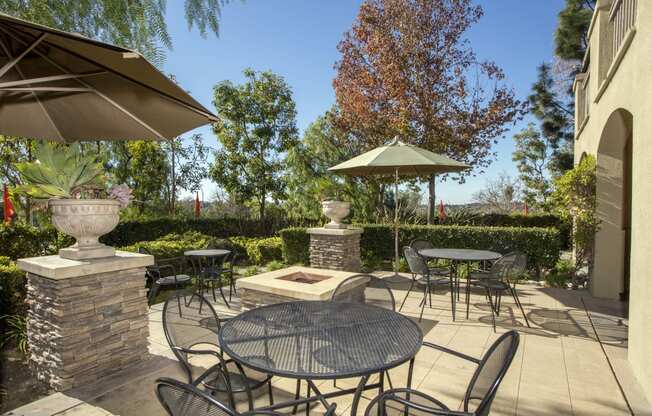 a patio with a firepit and tables and chairs
