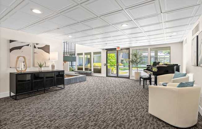 A spacious room with a piano, a couch, and a large window.